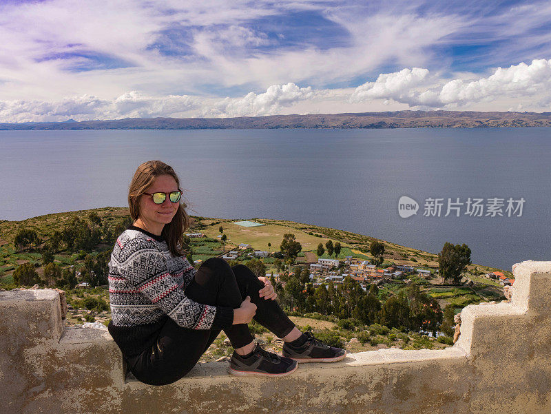 年轻女子的肖像坐在美丽的风景上的太阳岛，isla del sol，秘鲁